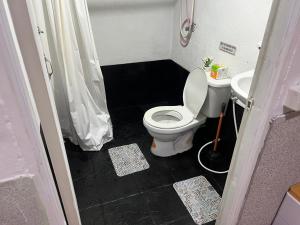 a small bathroom with a toilet and a sink at Sunset Serenity Cove in Ko Phangan