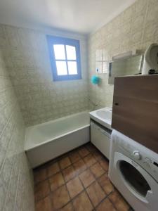ein Badezimmer mit einer Badewanne, einem Waschbecken und einer Waschmaschine in der Unterkunft Maison de Vacances Rayons de soleil in Notre-Dame-de-Monts + 11 Fotos