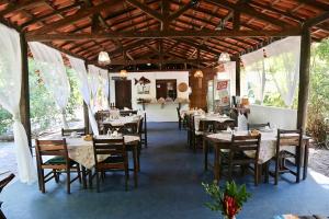 a dining room with tables and chairs in a restaurant at POUSADA e BANGALOS VILA DA BARCA in Ilha de Boipeba