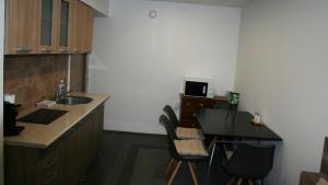 a room with a kitchen with a sink and a table at Friends - Promenade Suite Földszint in Balatonfüred