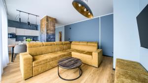 a living room with a couch and a table at Międzyzdroje Aquamarina, Sun & Snow in Międzyzdroje