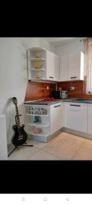een keuken met een gitaar op het aanrecht bij Glorianita sweethome,centro, FREE parking,SELF CHECK- IN in Šibenik