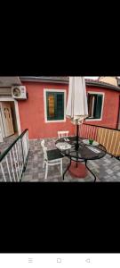 un patio con un tavolo, una sedia e un ombrellone di Glorianita sweethome,centro, FREE parking,SELF CHECK- IN a Šibenik