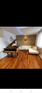- un salon avec un canapé et un piano dans l'établissement Glorianita sweethome,centro, FREE parking,SELF CHECK- IN, à Šibenik
