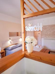 una habitación con una cama y un jarrón de flores sobre una mesa en House Kate, en Rovinj