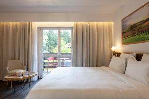 a hotel room with a large white bed and a window at Hôtel Restaurant La Vallée Noble, proche Eguisheim Colmar in Soultzmatt +70 photos
