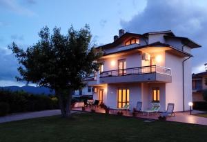 a large white house with a tree in the yard at Casa del Carmine in Anghiari
