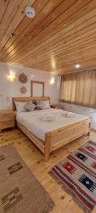 a bedroom with a large bed with a wooden ceiling at Noor El Din Dahabiya in Luxor +4 photos