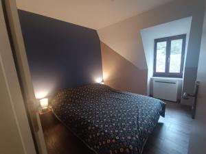 Un dormitorio con una cama con dos luces. en L'échappée belle de l'Aubrac, en Saint-Chély-dʼAubrac