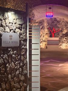 una stanza con un muro di pietra e un cartello di Villa Bossa ad Amalfi