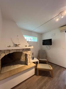 a living room with a stone fireplace and a tv at Seashell apartment in Vrsar