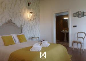 a bedroom with a bed with towels on it at MyStay - Casa de Tent'tugal in Montemor-o-Velho