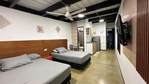 a bedroom with two beds and a tv in it at Malibu loft hotel in Medellín