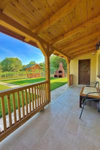 a large wooden porch with a view of a yard at Casa Phoenix in Uzlina +19 photos