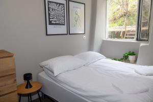 ein Schlafzimmer mit einem weißen Bett mit zwei Bildern an der Wand in der Unterkunft Apartment close to downtown in Akureyri