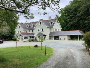 a large white house with a driveway at Gleann Fia Country House in Killarney