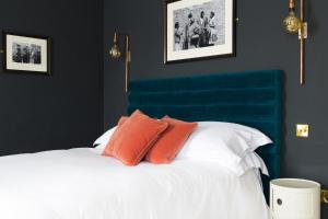 uma cama com duas almofadas laranjas em cima em The Porterhouse grill & rooms em Oxford