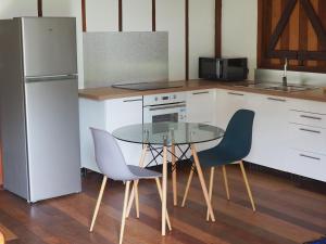a kitchen with a table and two chairs and a refrigerator at Kaz' Évasion plage & jacuzzi - REMIRE-MONTJOLY in Montjoly