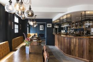a restaurant with a wooden bar and a table at The Porterhouse Grill and Rooms in Oxford