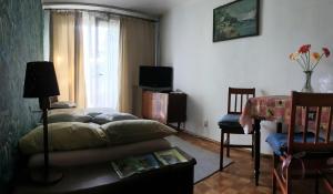 a living room with a bed and a table and a window at Zacisze in Białystok
