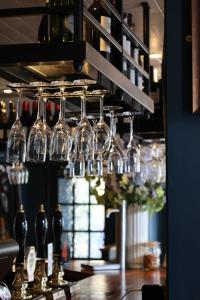un montón de copas de vino colgando sobre un bar en The Porterhouse grill & rooms en Oxford