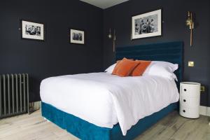 a bedroom with a blue and white bed with orange pillows at The Porterhouse grill & rooms in Oxford