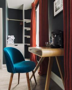 a room with a desk and a blue chair at The Porterhouse grill & rooms in Oxford