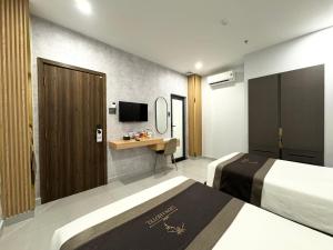 Habitación de hotel con 2 camas y escritorio en LION 3 HOTEL, en Can Tho