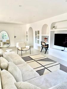 ein Wohnzimmer mit Couch und Fernseher in der Unterkunft La Villa Archipel Royan Suites & Pool Tennis in Saint-Sulpice-de-Royan