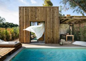 a small wooden house with a swimming pool at Ergon Beach House Nikiti in Nikiti