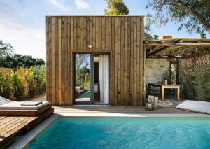 a small wooden house with a swimming pool at Ergon Beach House Nikiti in Nikiti