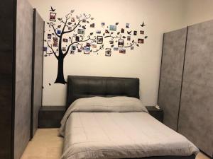 a bedroom with a bed and a tree on the wall at Bross apartament in Salerno