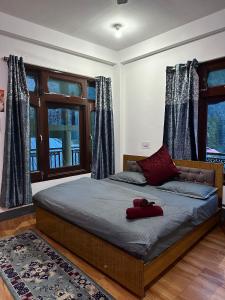 a bedroom with a bed with a red object on it at Pahadirovers Homestay & Cafe in Kasol