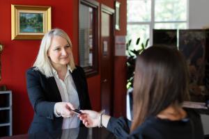 a woman is standing in front of a mirror at Hôtel Restaurant La Vallée Noble, proche Eguisheim Colmar in Soultzmatt