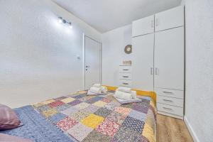a bedroom with a bed with a quilt on it at Villa Grammy in Bol