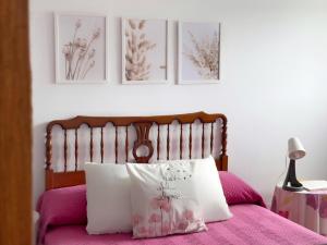 a bedroom with a pink bed with a wooden headboard at Casona de la Loma - 2806 in San Mamés de Meruelo