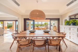 a dining room with a wooden table and chairs at Seaside Bliss with pool and spectacular view in Las Minas