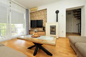 salon ze stolikiem kawowym i kominkiem w obiekcie Apartment Sanja Kolovare Beach w mieście Zadar