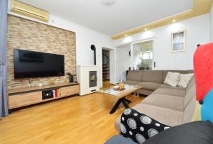 salon z kanapą i telewizorem z płaskim ekranem w obiekcie Apartment Sanja Kolovare Beach w mieście Zadar