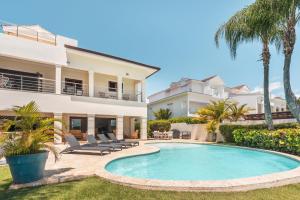a villa with a swimming pool and palm trees at Seaside Bliss with pool and spectacular view in Las Minas