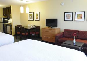 a hotel room with a bed and a dining room at TownePlace Suites Redding in Redding