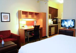 um quarto de hotel com uma cama, uma secretária e uma cozinha em TownePlace Suites Redding em Redding
