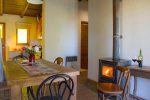 a kitchen with a table and a wood stove at Finca La Pichona in Los Árboles