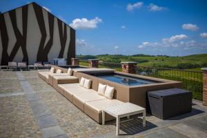 een zwembad met banken en stoelen op een patio bij Montalbera Wine Suites in Montemagno