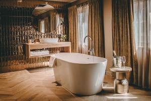 a bathroom with a large tub and a mirror at Hotel Centraal Baarlo in Baarlo