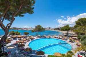 a view of a pool and a beach with umbrellas at Leonardo Royal Hotel Ibiza Santa Eulalia in Es Cana