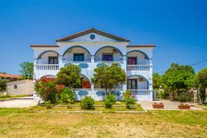 a large white house with trees in front of it at Babis Studios in Kalamaki