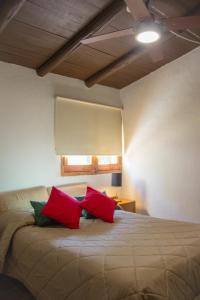 a bedroom with a bed with red pillows on it at Finca La Pichona in Los Árboles
