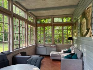 a screened in porch with windows and a couch at Oaza Niegocin - Domek Nad Jeziorem in Ruda +17 photos