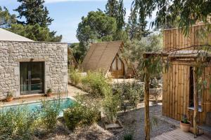 a house in the middle of a garden with a pool at Ergon Beach House Nikiti in Nikiti